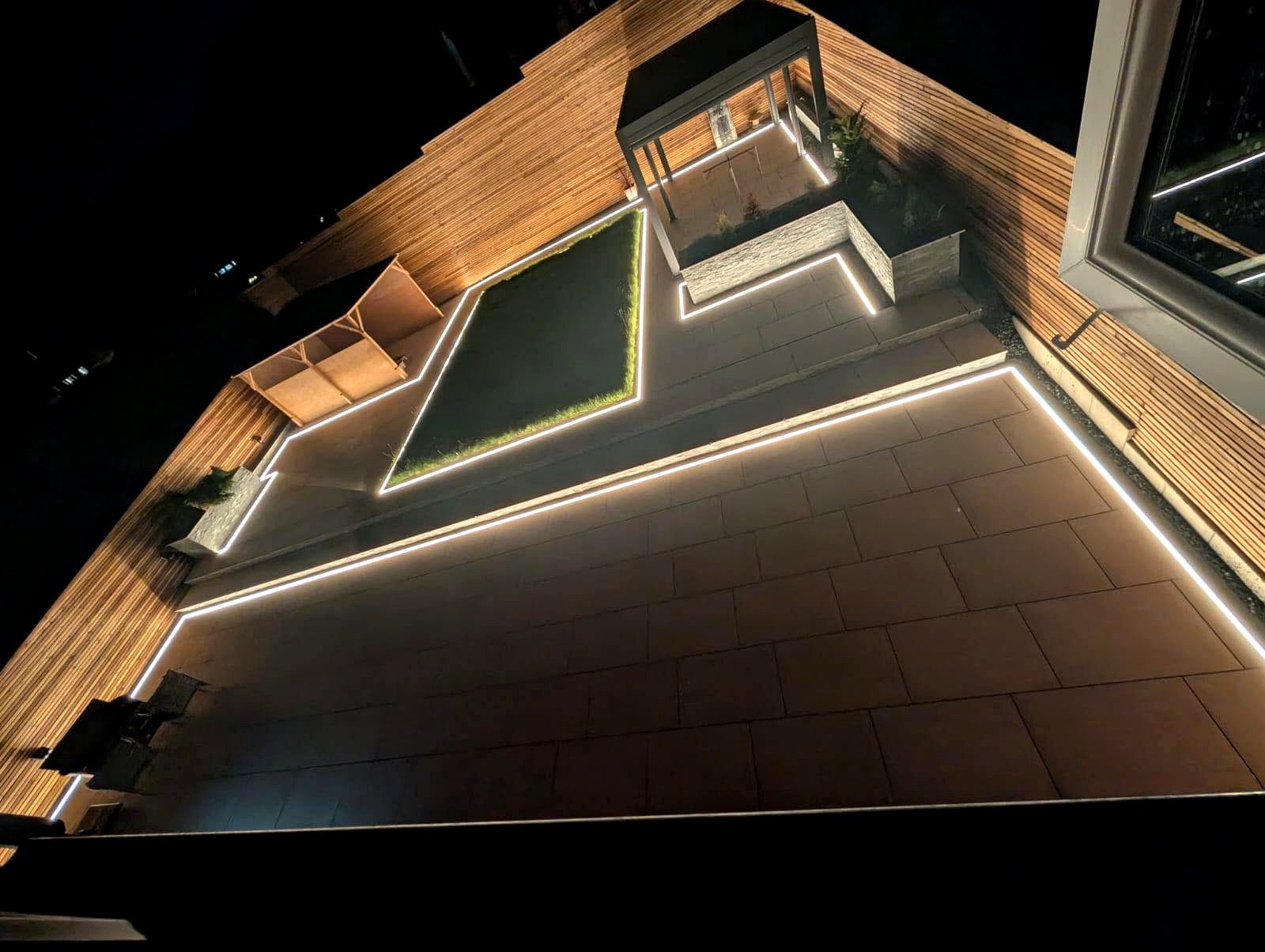 LED strip lighting around a garden patio at night.